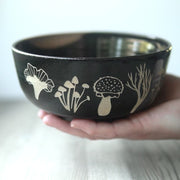 black ramen bowl engraved with various mushrooms