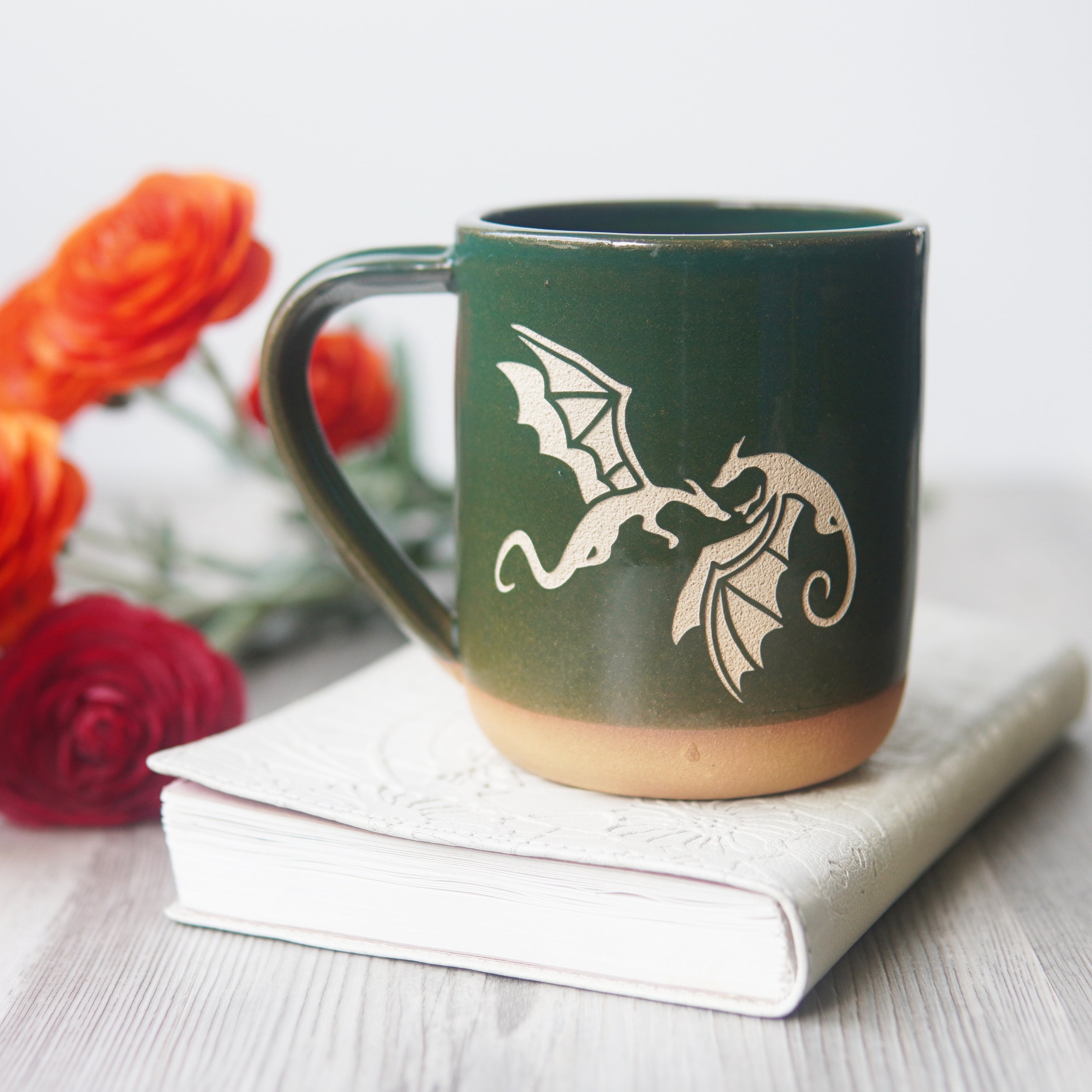 dragons engraved on a pine green mug