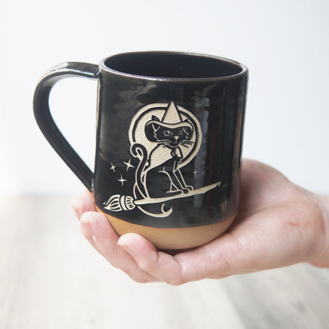 witch cat mug, held in a hand