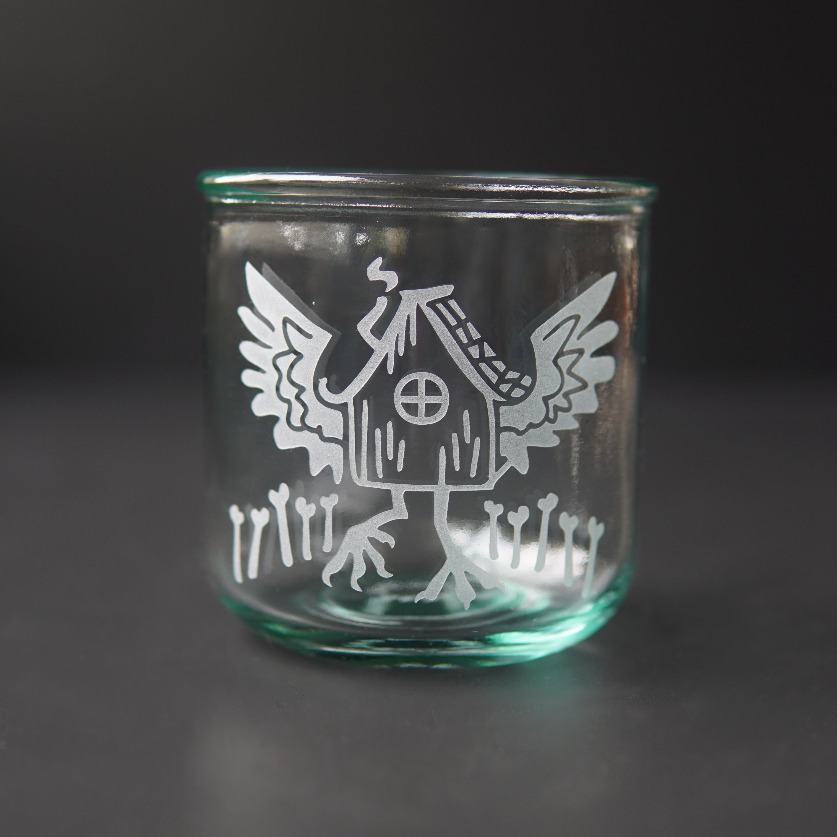 baba yaga's hut with wings etched onto a short green-tinged glass