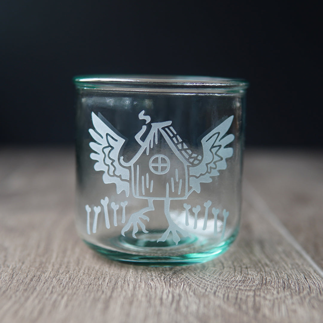 baba yaga's hut with wings etched onto a short green-tinged glass