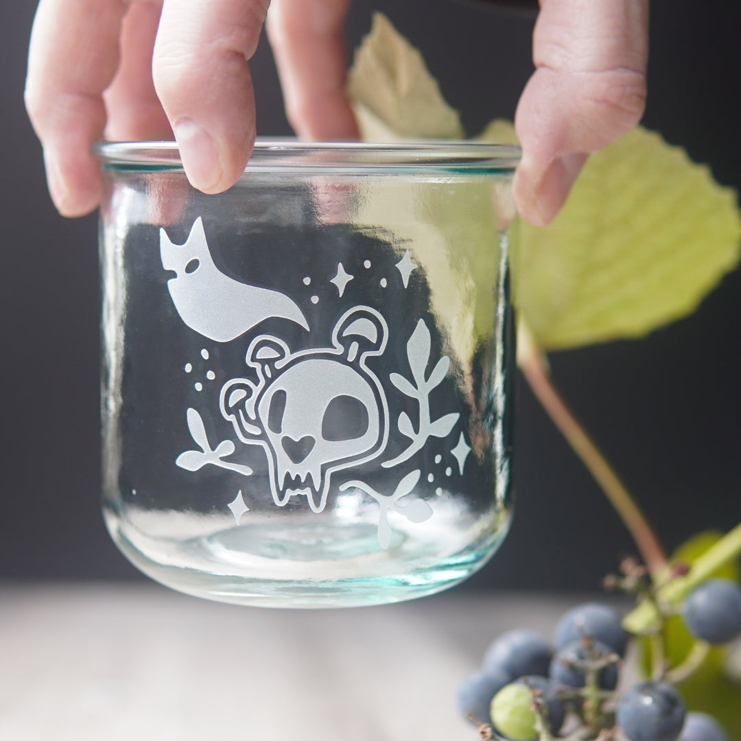 short haunted cat skull glass held by a hand