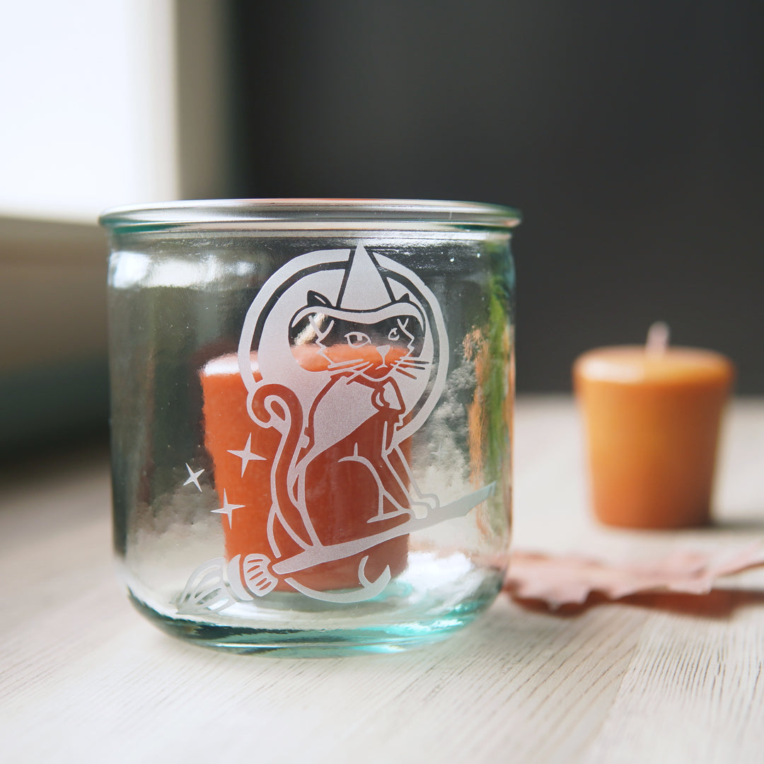 witch cat engraved onto a short glass with votive candles