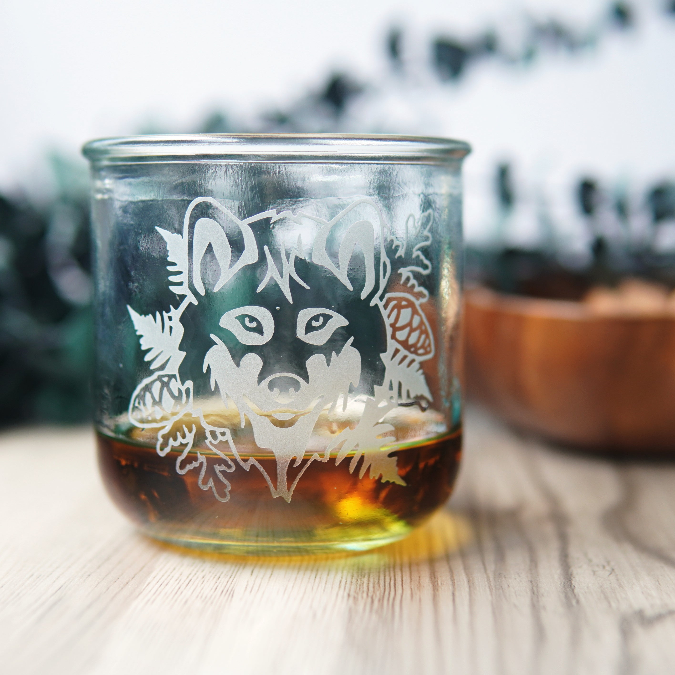 wolf etched onto a short glass of whiskey