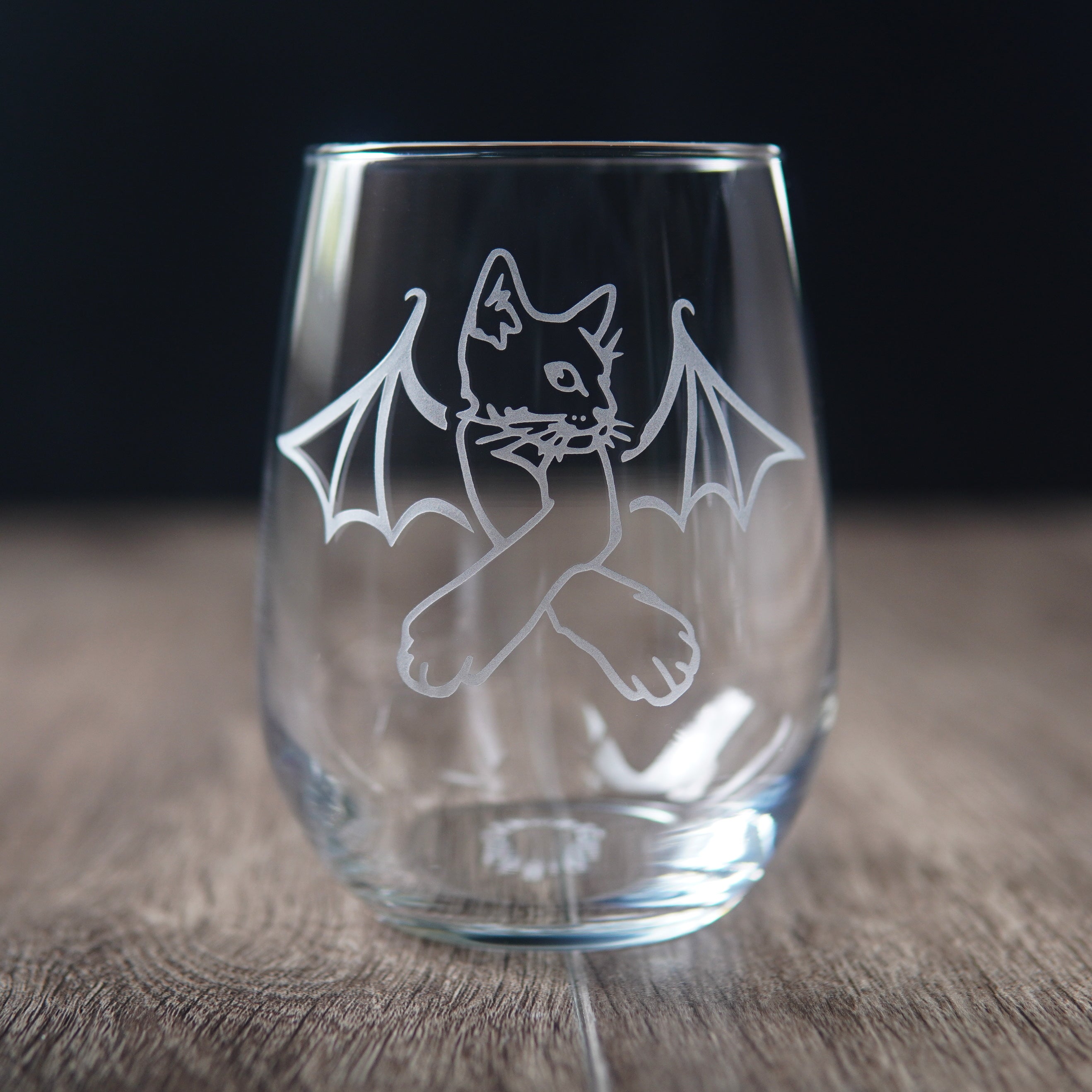 stemless wine glass engraved with a cat with crossed arms and bat wings