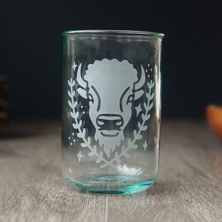 Bison engraved on a tall blue-tinged recycled glass cup