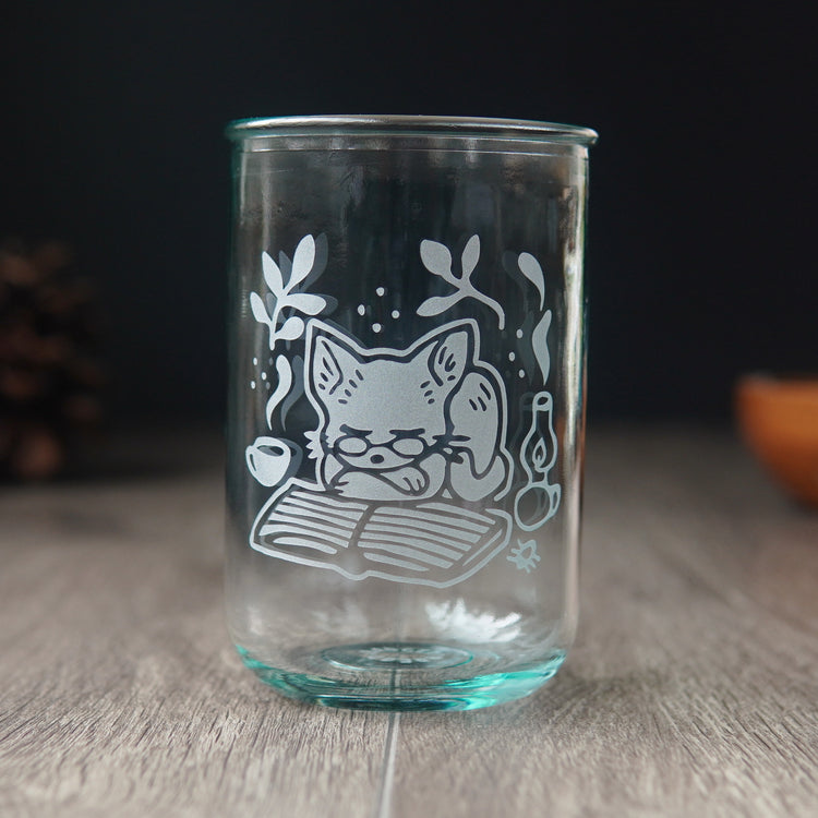 tall recycled glass cup engraved with a cat wearing glasses, sleeping on a book