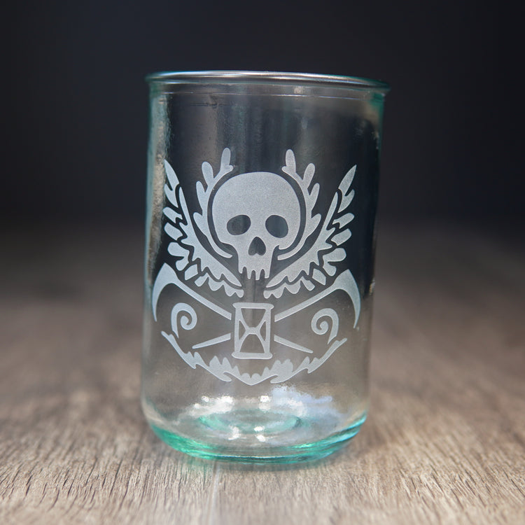 winged skull etched onto a tall tumbler