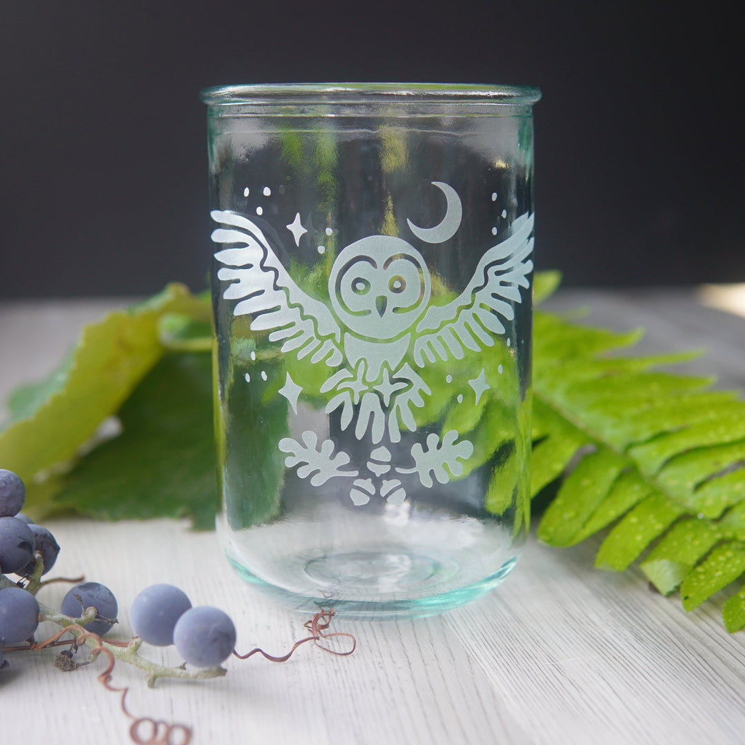 engraved owl tall glass, next to grapes and fern frond