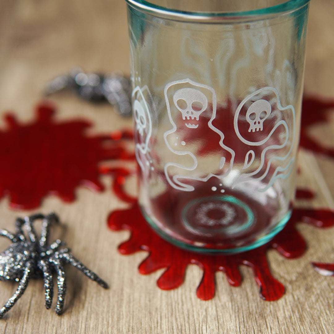 floating skull ghosts etched on a tall glass with fake blood and plastic spiders