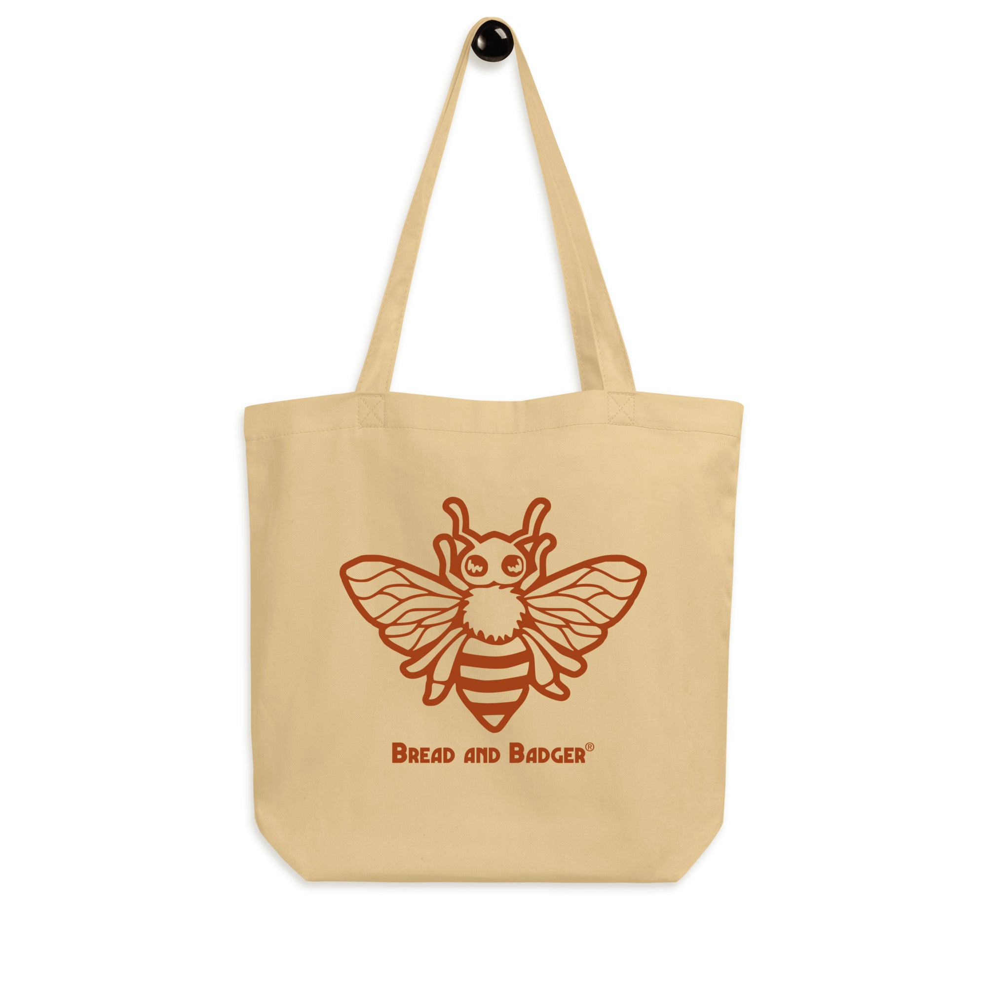Beige tote bag with a red bee illustration and 'Bread and Badger' text on a white background