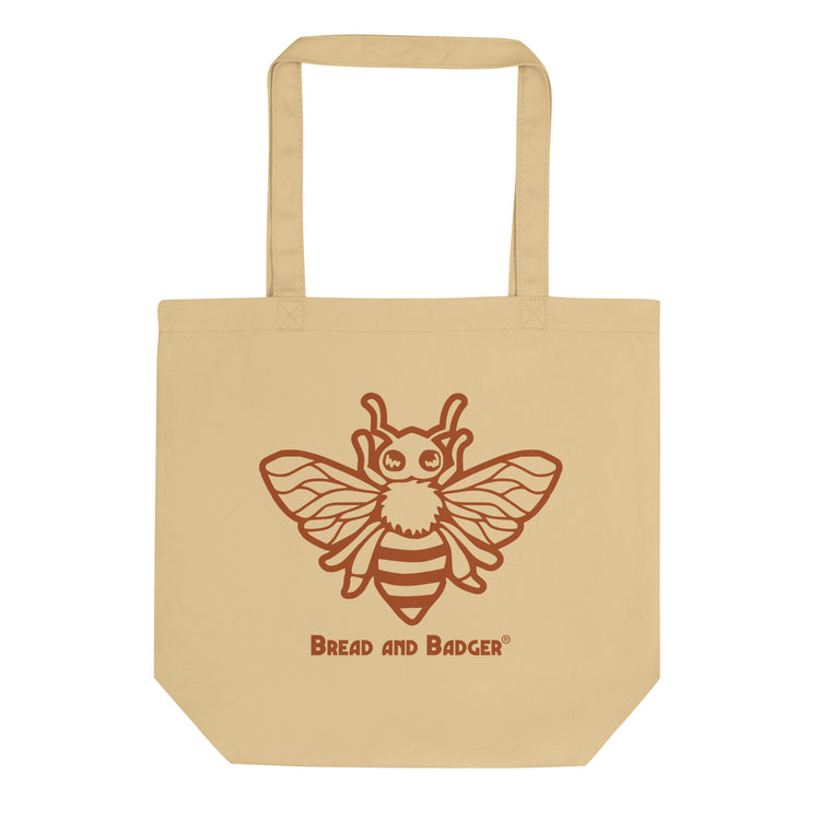 Beige tote bag with a bee design and 'Bread and Badger' text on a white background