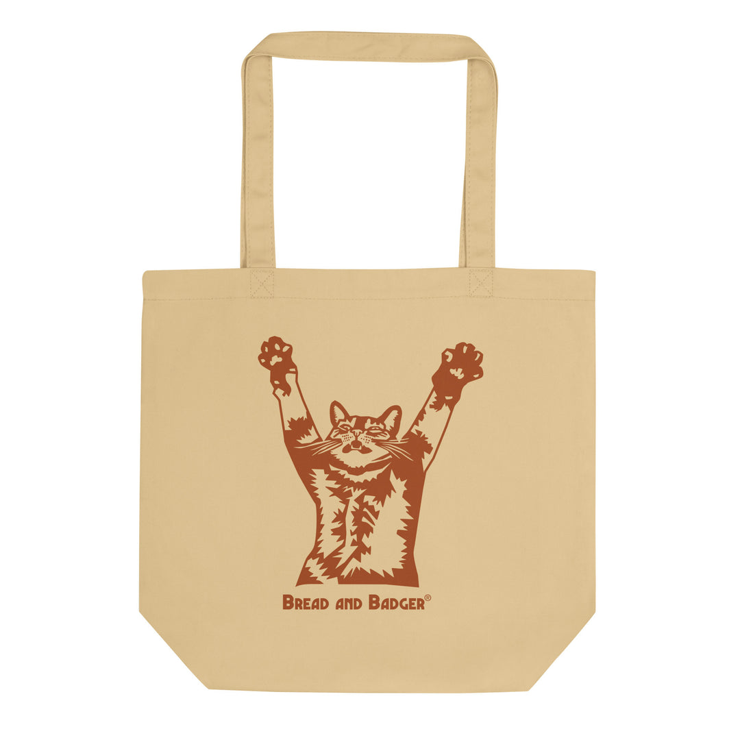 Beige tote bag with a graphic of a cat reaching its arms up, and 'Bread and Badger' text on a white background