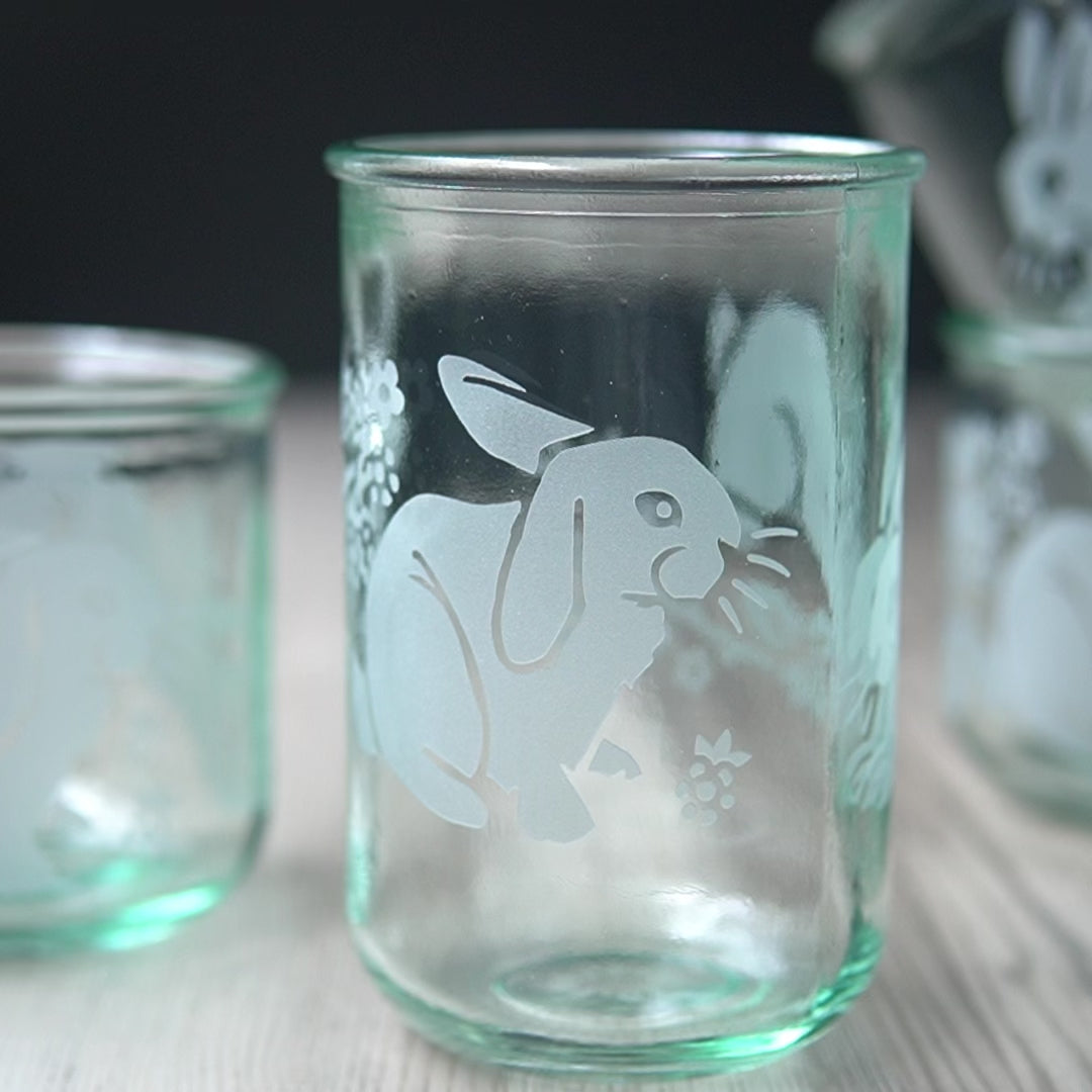 lop-eared and leaping rabbits with blackberry branches etched onto tall  glassware, rotated by a hand