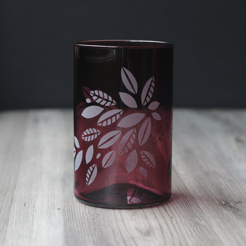 Tea Leaves engraved onto a blown glass tumbler in translucent black cherry red