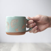 Ginkgo mug in Rain blue-grey, held in a hand
