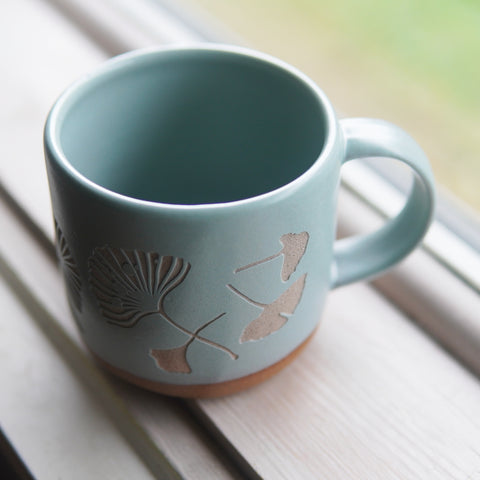 Ginkgo mug in Rain blue-grey on a windowsill
