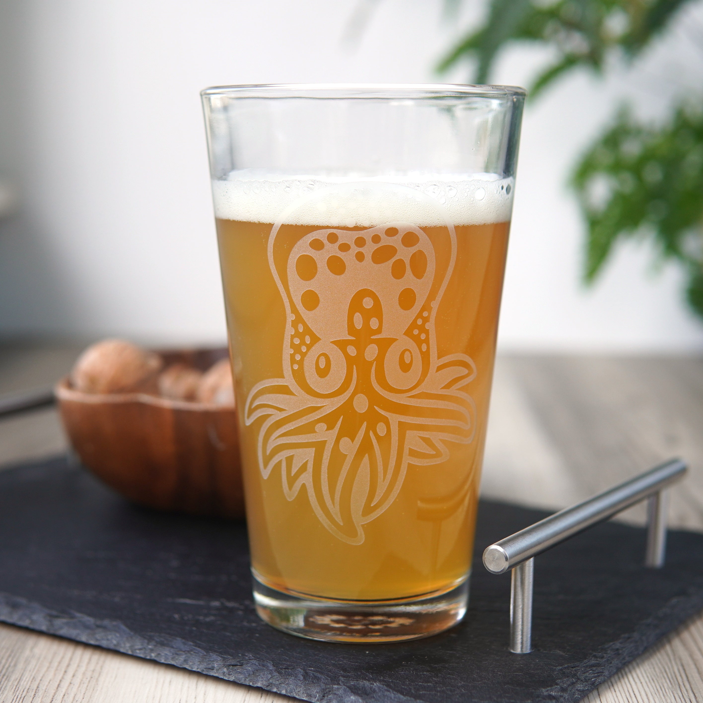 pint glass etched with a cute baby octopus. It has dots across its head and a few tentacles