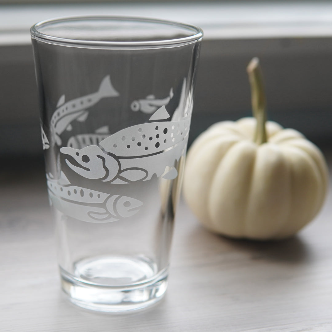 Salmon pint glass next to a small white pumpkin